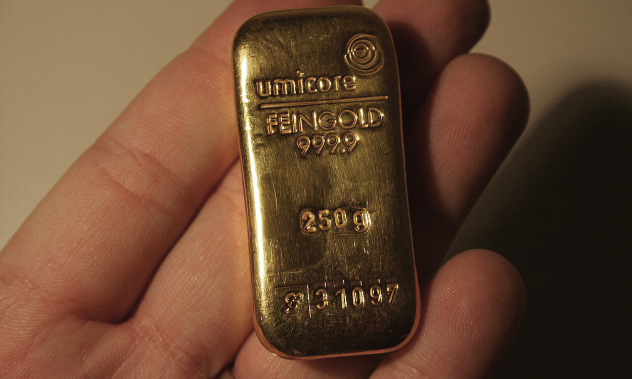 Un lingot d'or de 250 grammes dans une main